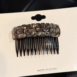 Macro shot of sparkling grey rhinestones on a non-slip black hair comb for women