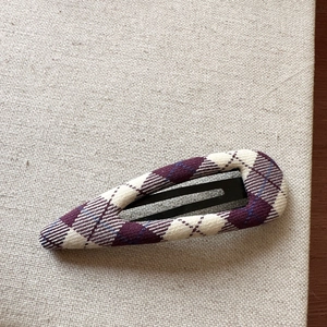 Macro detail of purple and white plaid fabric texture on a waterdrop BB hair clip