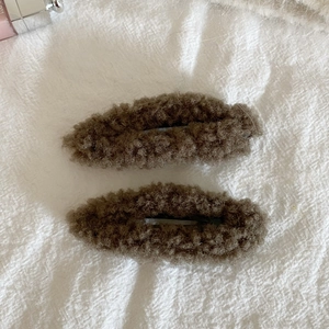 Detail view of dark brown plush velvet fabric covered oval hair clips for autumn winter
