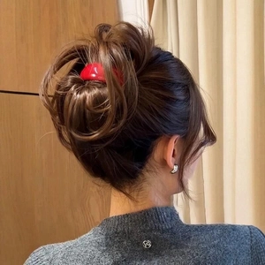 Glossy red acetate spring clip for bun hairstyles on brunette hair with gray sweater