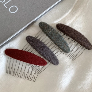 Elegant four-piece comb hair clips in red and tweed textures on a soft plush background