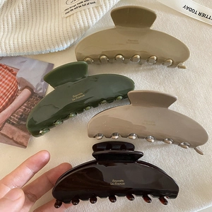 Set of four glossy acetate hair claws in beige, green, and brown with French lettering