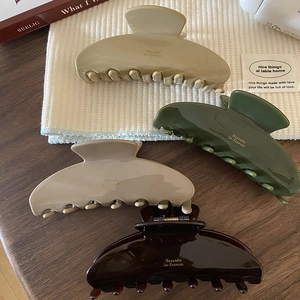 Set of four large acetate hair claws in beige, green, pink, and tortoiseshell brown