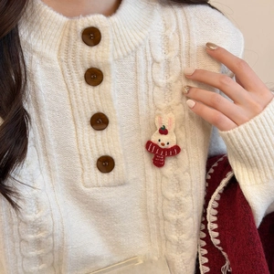 Close-up of cute rabbit embroidery with red scarf on beige chunky cable knit sweater