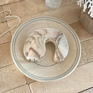 Close-up of marble pattern acetate hair claw clip with elegant arched design