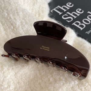 Close-up of brown acetate hair claw clip featuring golden Barrette la France text detail