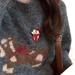 Cute embroidered puppy brooch with red hat on a grey sweater, winter fashion accessory