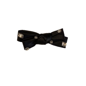 Barrette à cheveux nœud en satin noir ornée de six strass brillants sur fond blanc