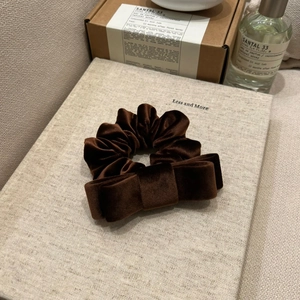 Macro view of velvet hair scrunchie with double bow in chocolate brown fabric