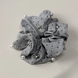 Dettaglio di elastico grigio a pois con perle bianche e strass scintillanti