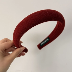Detail of red sponge padded headband with soft velvet texture and handmade label