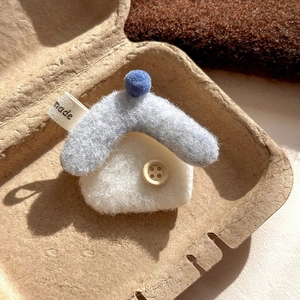 Macro shot of a handmade blue felt house brooch with wood button and made label