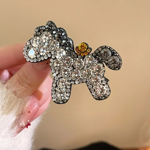 Close-up of sparkling crystal horse hairpin with detailed rhinestone pavé setting