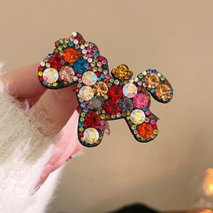 Macro shot of horse hair clip with multicolored sparkling crystals and red gemstones
