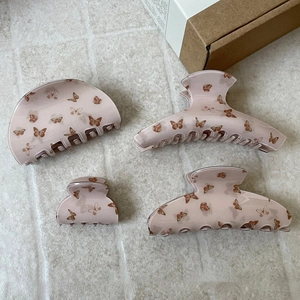 Set of four sweet pink butterfly hair claws in various sizes with high-gloss resin finish
