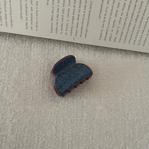 Detail of butterfly hair claw clip with vintage blue denim texture and red polka dots
