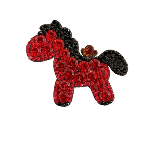Sparkling red crystal horse hair clip with luxury orange gemstone accent and dark studs