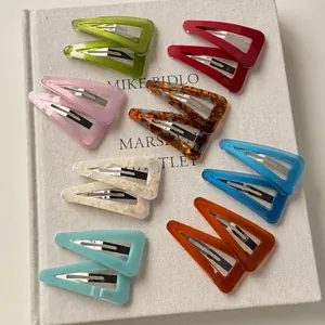 Colorful acetate triangular hair clips set on a book, vintage geometric hair accessories