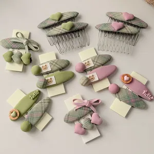 Detailansicht der rosa und salbeigrünen Haarschmuck-Sets mit Schleifen und Herzen