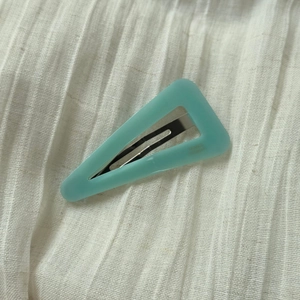 Macro shot of mint green geometric hair clip with France Handmade text on fabric