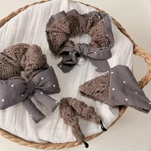 Polka dot knit hair scrunchie with bow and pearl charm in brown and grey tones