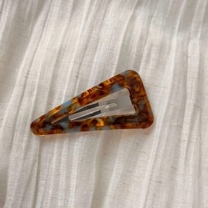 Detail of triangle acetate hair clip with tortoiseshell pattern and gold France handmade text