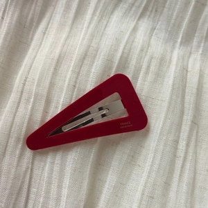 Detail of red triangle acetate hair clip with gold France Handmade lettering and metal buckle