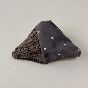 Detailed close-up showing fabric texture contrast and polka dot pattern on hair tie