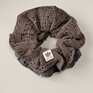 Macro detail of dark grey knit scrunchie with lace texture and polka dot lining