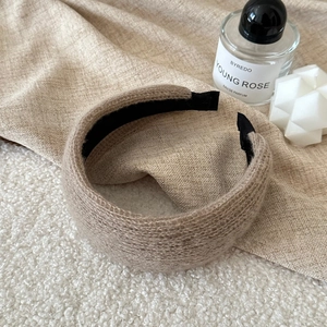 Detail of oatmeal knitted headband showing soft wool-like texture and non-slip inner grip