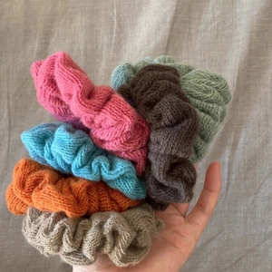 Set of six colorful knit scrunchies in pastel tones on natural linen background