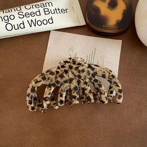 Macro view of a large leopard print acetate hair claw clip with a glossy finish