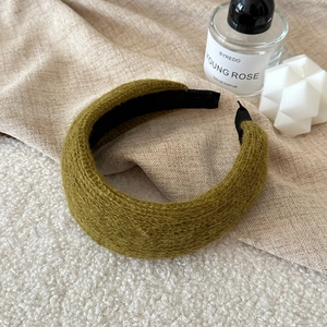 Detailed close-up of the olive green knitted headband with thick texture and inner lining