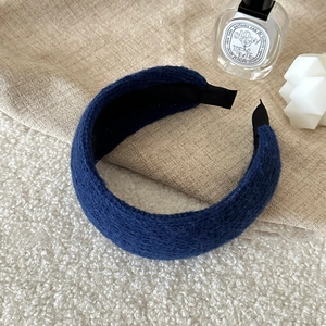 Detail of dark blue chunky knit wide headband with textured fabric and reinforced ends
