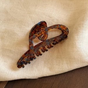 Detailed view of large acetate hair claw clip with classic tortoiseshell pattern design