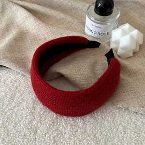 Close-up of red knitted wide headband with detailed texture and non-slip lining
