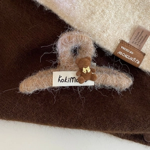 Détail d'une pince à cheveux en peluche marron avec ours et étiquette KokiMa douce