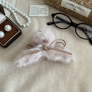 Détail de la pince à cheveux en peluche avec texture douce et décoration en ruban