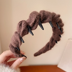 Gros plan du bandeau en tricot marron foncé avec motif de torsades texturées douces