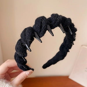 Gros plan du serre-tête tricoté noir avec pointes crantées et détails de maille douce