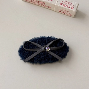 Detailansicht der eleganten Kunstfell-Haarklammer mit grauer Schleife und Kristall