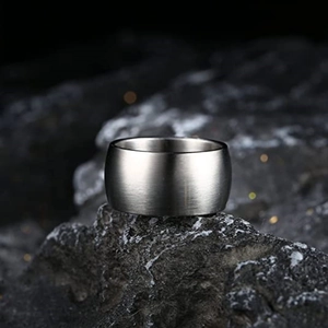 Nahaufnahme 12mm breiter gebürsteter Titanstahlring mit mattem Finish auf Fels