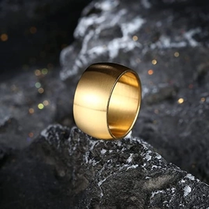 Makroansicht eines 12mm breiten goldenen Edelstahlrings auf einer Felsstruktur