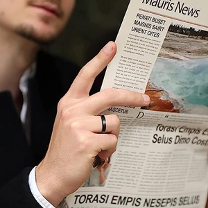 Homme d'affaires portant une bague en acier noir mat de 4mm lisant un journal