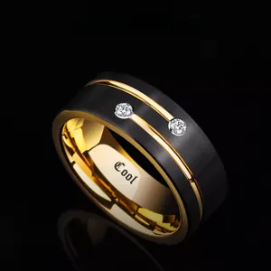 Dettaglio macro di anello in acciaio nero spazzolato con interno oro e incisione