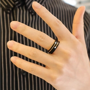 Anello da uomo in acciaio titanio nero e oro con zirconi indossato sul dito