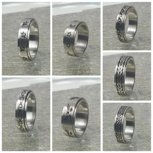 Detalle macro de anillos giratorios de acero con grabados de naturaleza y luna