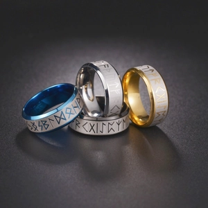 Detailed view of Viking rune rings in gold, blue, polished and brushed silver finishes
