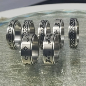 Detalle de los anillos giratorios de acero plateado con grabados de naturaleza y animales