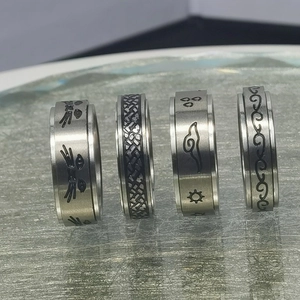 Detalle de cuatro anillos giratorios de acero inoxidable con grabados de gatos y astros